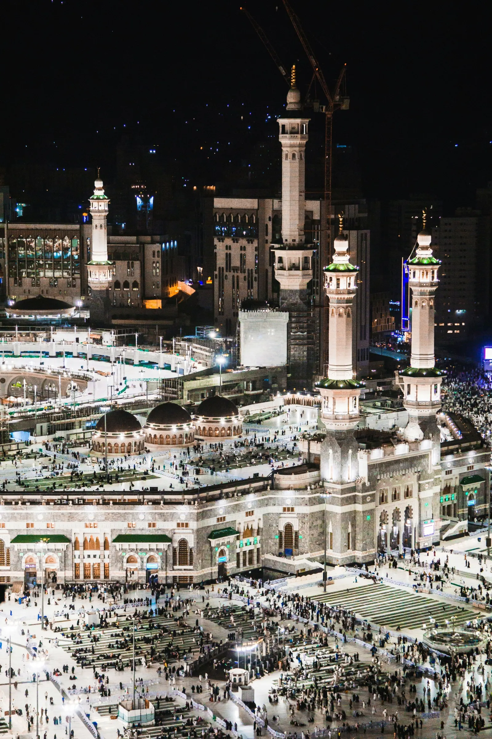 Masjid al-Haram at night, its courtyard filled with worshippers