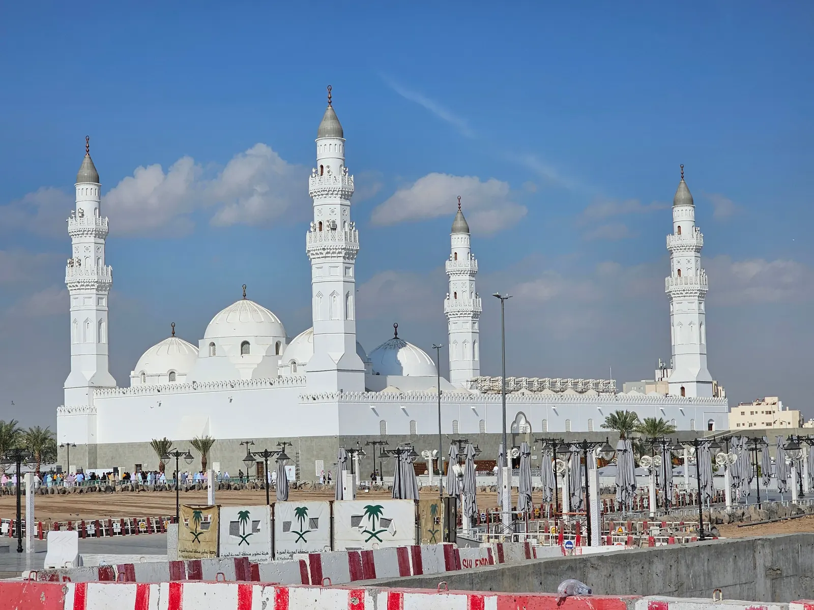 Quba Mosque with its white domes and minarets, seen from a nearby hill