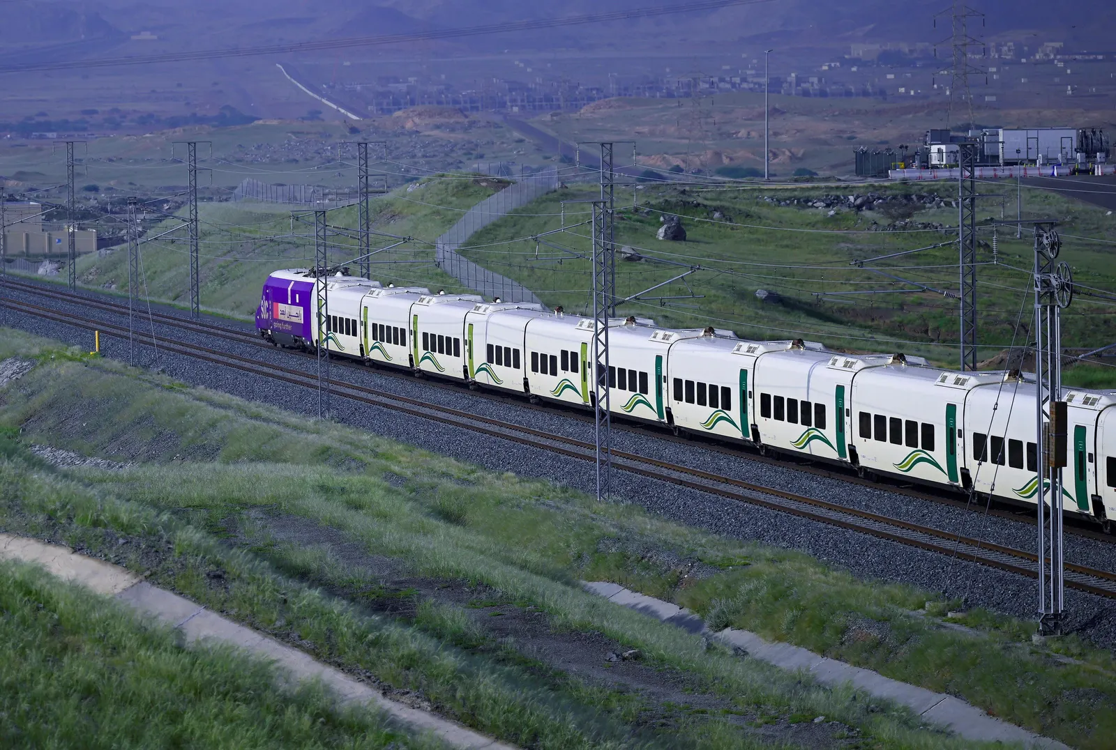 A Haramain High Speed Railway train travelling through open countryside