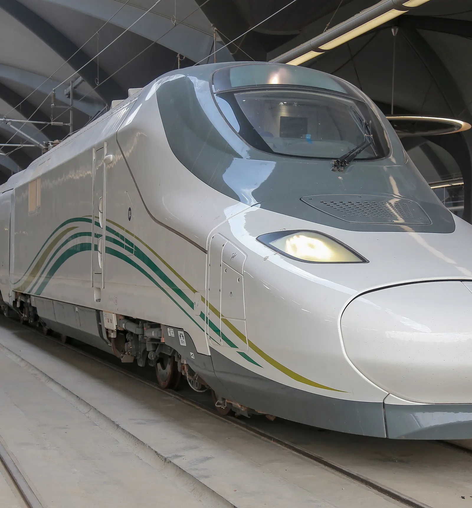 A white Haramain High Speed Railway train waiting at a station platform